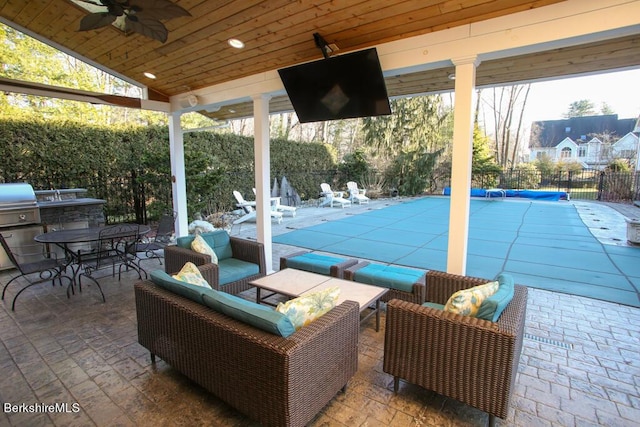 view of patio featuring an outdoor hangout area, a covered pool, and ceiling fan