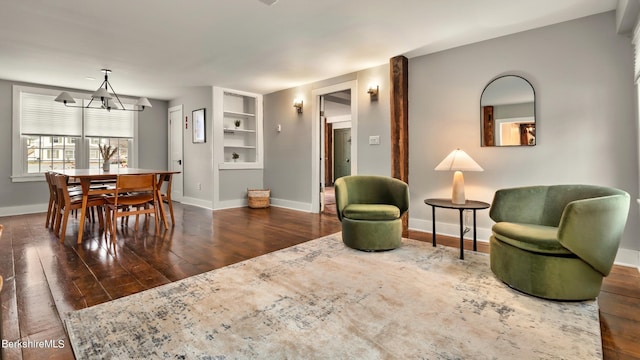 interior space featuring built in features, a chandelier, and dark hardwood / wood-style floors