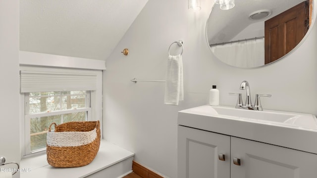 bathroom with vanity and lofted ceiling