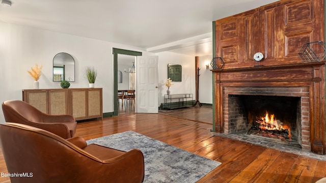 living room featuring a fireplace and dark wood-type flooring