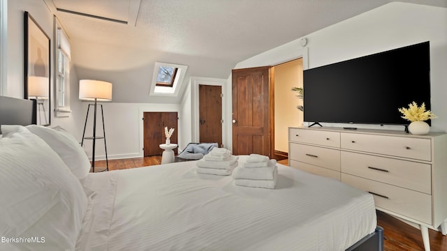 bedroom with dark hardwood / wood-style flooring and lofted ceiling with skylight