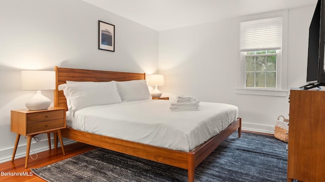 bedroom with dark wood-type flooring