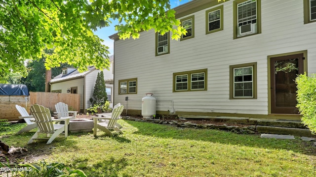 back of house featuring a fire pit and a yard