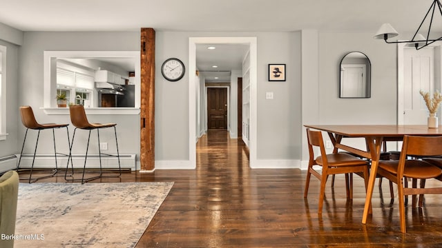 dining room featuring dark hardwood / wood-style floors and a baseboard heating unit