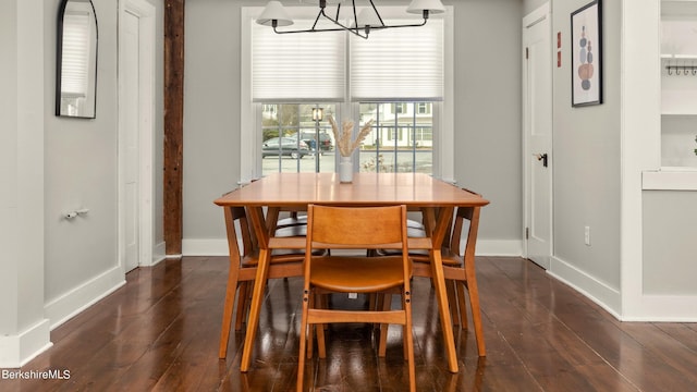 dining space featuring an inviting chandelier and dark wood-type flooring