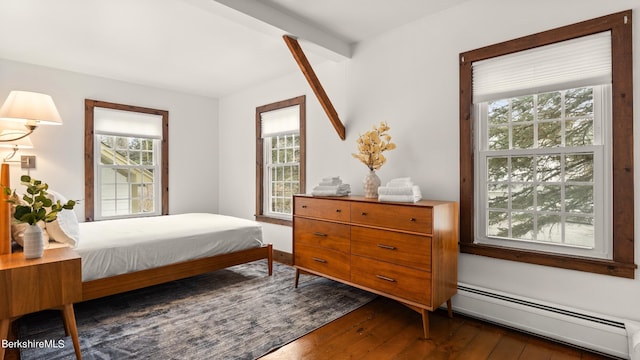 bedroom featuring beamed ceiling, dark hardwood / wood-style flooring, and baseboard heating