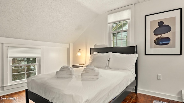 bedroom with a textured ceiling and vaulted ceiling