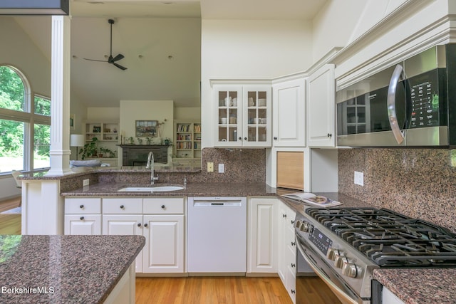 26 N Egremont Rd, Great Barrington, MA 01230 - kitchen featuring stainless steel appliances, light wood-style floors, white cabinets, a high ceiling, and dark stone counters