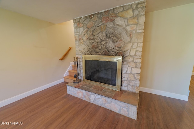 details featuring baseboards, a fireplace, and wood finished floors