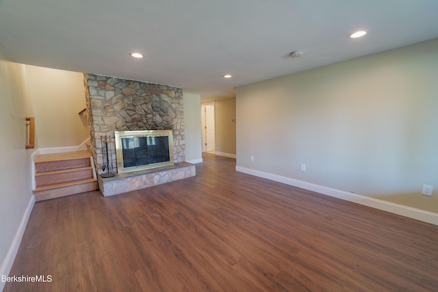 unfurnished living room with a fireplace, wood finished floors, stairway, baseboards, and recessed lighting
