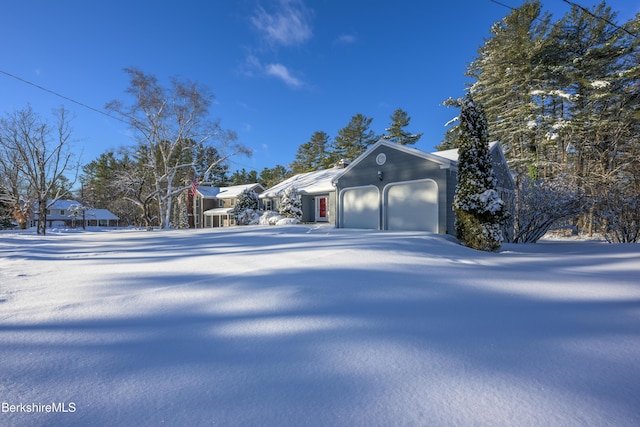 view of snowy exterior featuring a garage