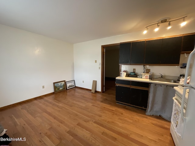 395 Laurel St, Lee, MA 01238 - kitchen featuring light wood finished floors, light countertops, dark cabinetry, and baseboards