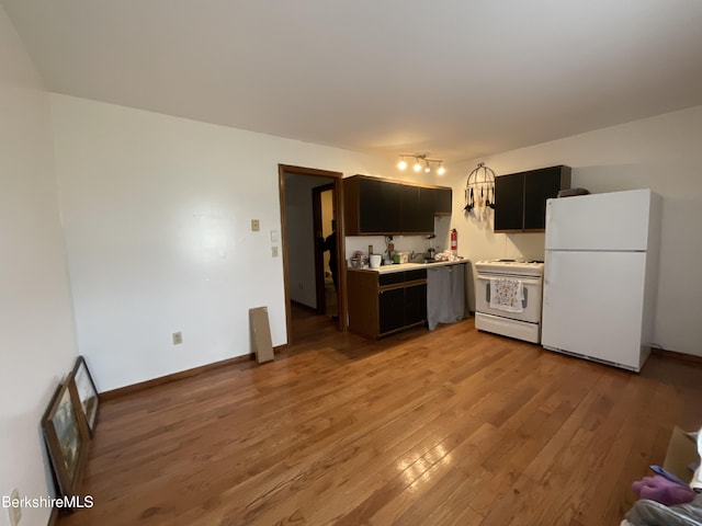 395 Laurel St, Lee, MA 01238 - kitchen with white appliances, light wood-style flooring, light countertops, dark cabinets, and baseboards