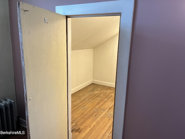 spacious closet featuring lofted ceiling, radiator, and hardwood / wood-style floors