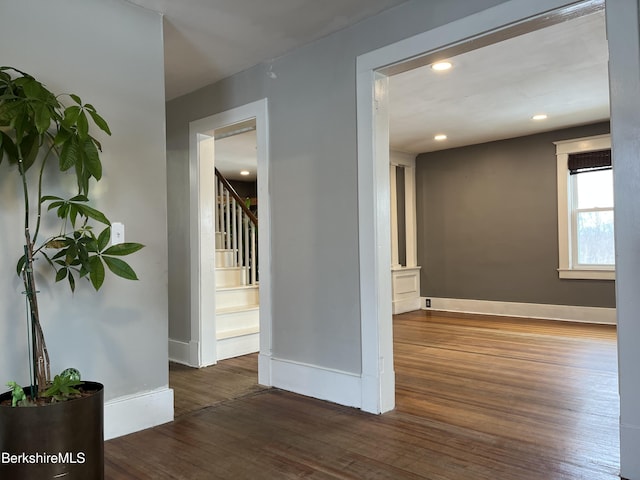 empty room with stairs, baseboards, wood finished floors, and recessed lighting