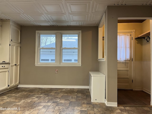 interior space featuring an ornate ceiling and baseboards