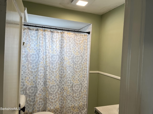 full bathroom featuring toilet and a shower with curtain