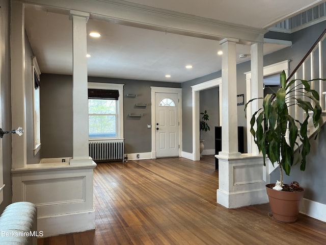 foyer entrance with decorative columns, recessed lighting, radiator, baseboards, and hardwood / wood-style flooring