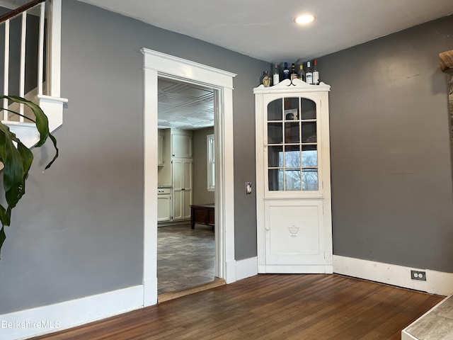 unfurnished dining area with wood finished floors and baseboards