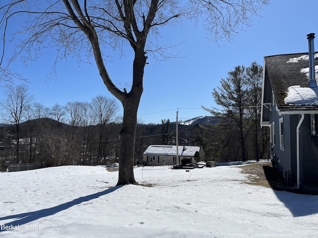 yard covered in snow with a mountain view