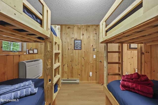 112 Silver St, Lanesborough, MA 01237 - bedroom with a baseboard radiator, wood walls, wood finished floors, and a textured ceiling