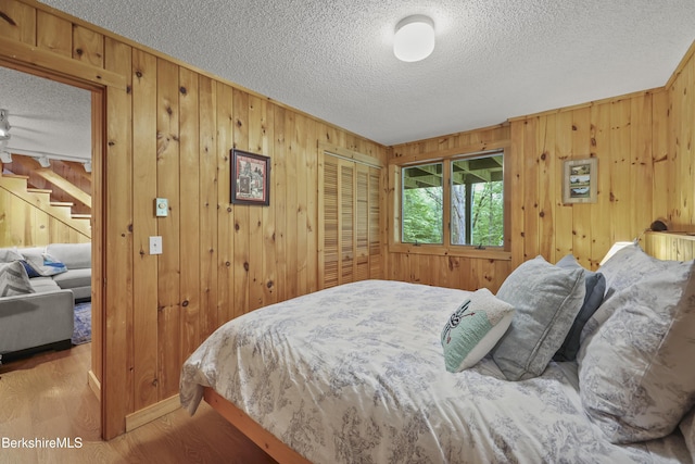 112 Silver St, Lanesborough, MA 01237 - bedroom with a textured ceiling, wooden walls, wood finished floors, and a closet