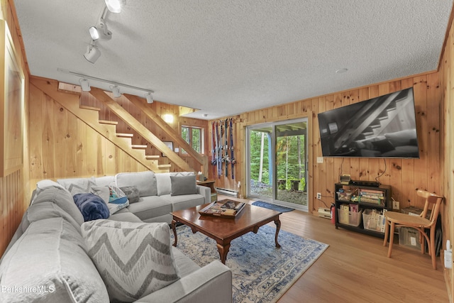 112 Silver St, Lanesborough, MA 01237 - living area featuring wood walls, rail lighting, stairs, wood finished floors, and a baseboard heating unit