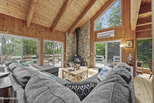112 Silver St, Lanesborough, MA 01237 - living area with a wood stove, an AC wall unit, hardwood / wood-style floors, plenty of natural light, and a wood ceiling with exposed beams