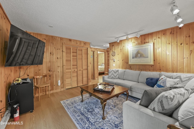 112 Silver St, Lanesborough, MA 01237 - living area with rail lighting, wooden walls, light wood-style floors, and a textured ceiling