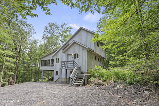 112 Silver St, Lanesborough, MA 01237 - view of front facade featuring stairs, a wooden deck, dirt driveway, and a sunroom