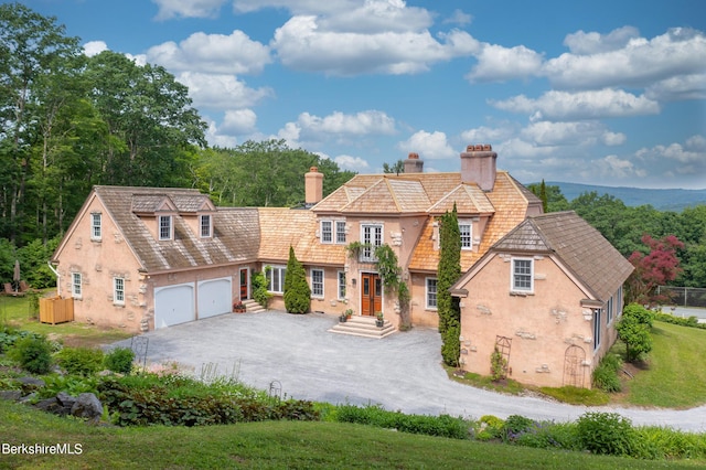 76 Lenox Rd, West Stockbridge, MA 01266 - view of front of house featuring dirt driveway, stucco siding, a garage, and a chimney