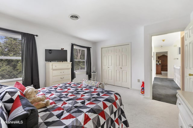 carpeted bedroom with a closet and visible vents