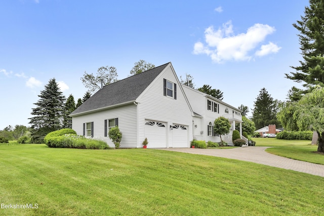 view of side of home featuring a garage, decorative driveway, and a lawn