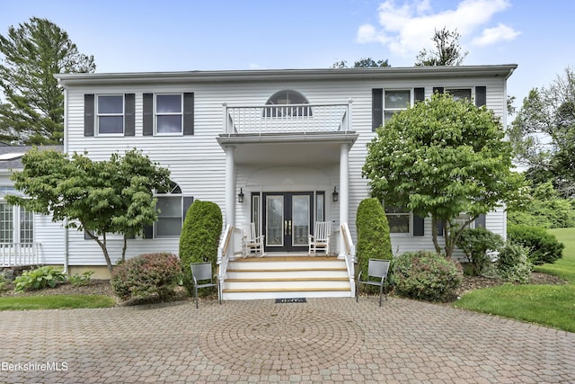 view of front of home with french doors and a balcony