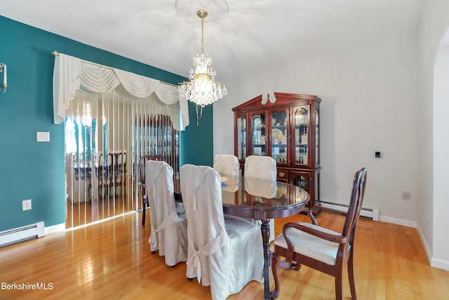 dining area featuring baseboards, baseboard heating, wood finished floors, and a notable chandelier