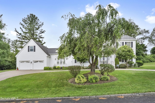 view of front facade with a garage, decorative driveway, and a front yard