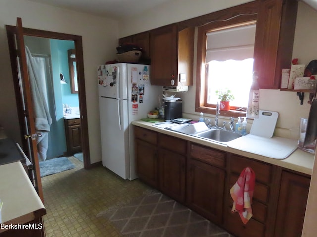 16-18 Hoosac St, Adams, MA 01220 - kitchen featuring freestanding refrigerator, a sink, light countertops, and brown cabinets