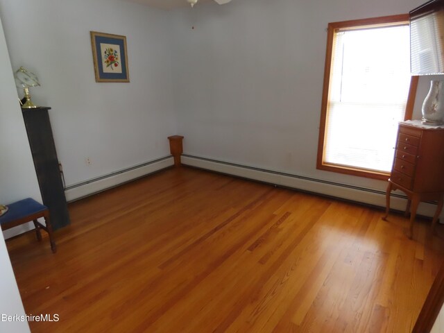 16-18 Hoosac St, Adams, MA 01220 - empty room with baseboard heating, light wood-style floors, and a ceiling fan