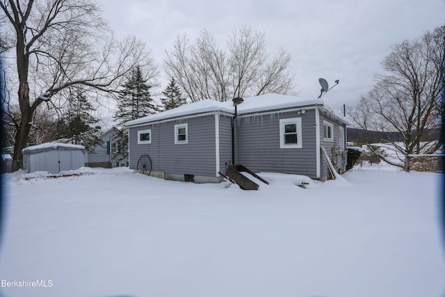 view of snow covered back of property