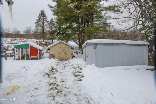 yard covered in snow featuring a storage unit