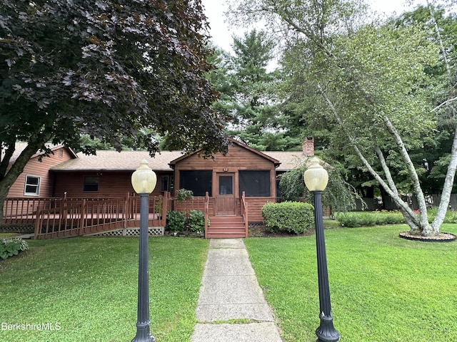 ranch-style home with roof with shingles, a chimney, and a front lawn