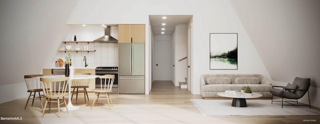 kitchen featuring tasteful backsplash, wall chimney exhaust hood, and appliances with stainless steel finishes