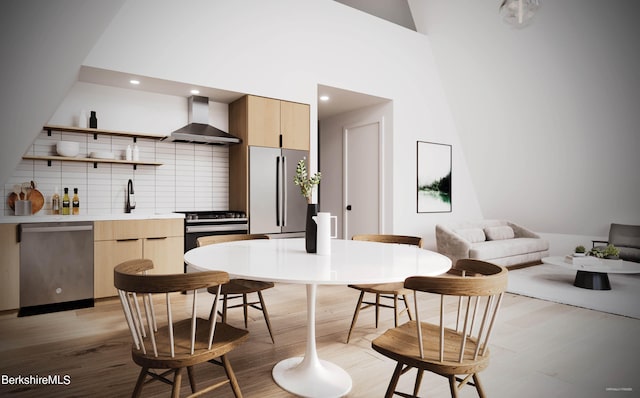 kitchen with backsplash, wall chimney exhaust hood, stainless steel appliances, and light brown cabinetry