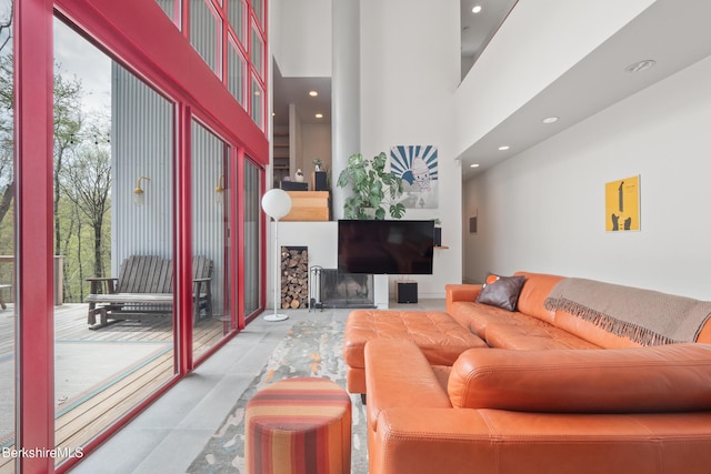 living area featuring a towering ceiling, tile patterned floors, and recessed lighting