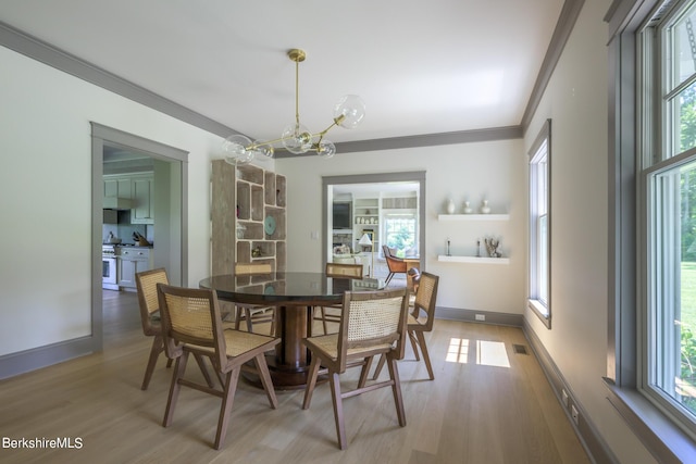 dining space with an inviting chandelier, a wealth of natural light, and crown molding