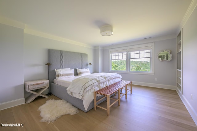 bedroom featuring light wood-type flooring and ornamental molding