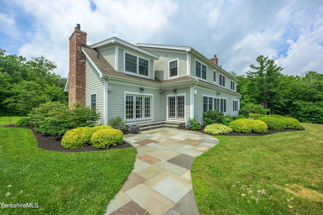 rear view of property with a patio and a lawn