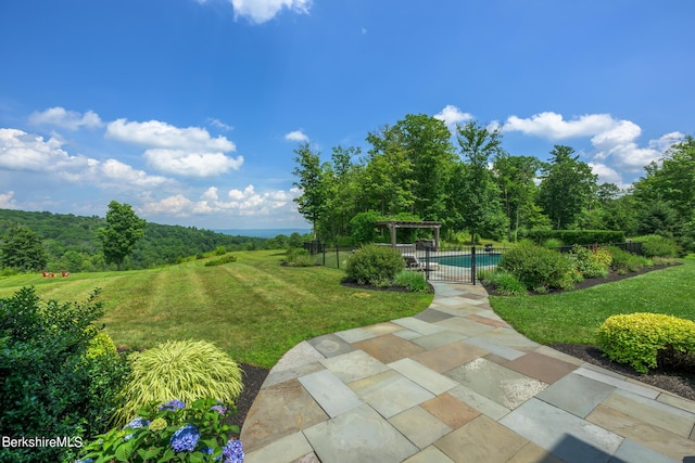 view of property's community with a yard, a pergola, a patio area, and a swimming pool