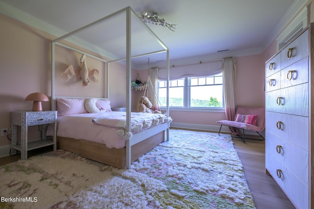 bedroom with light hardwood / wood-style flooring and ornamental molding