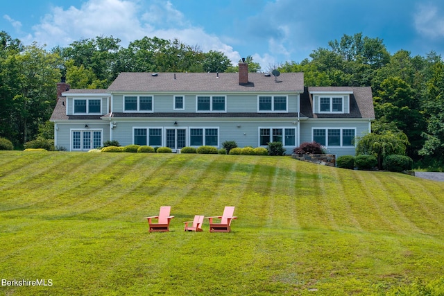 rear view of property featuring a yard